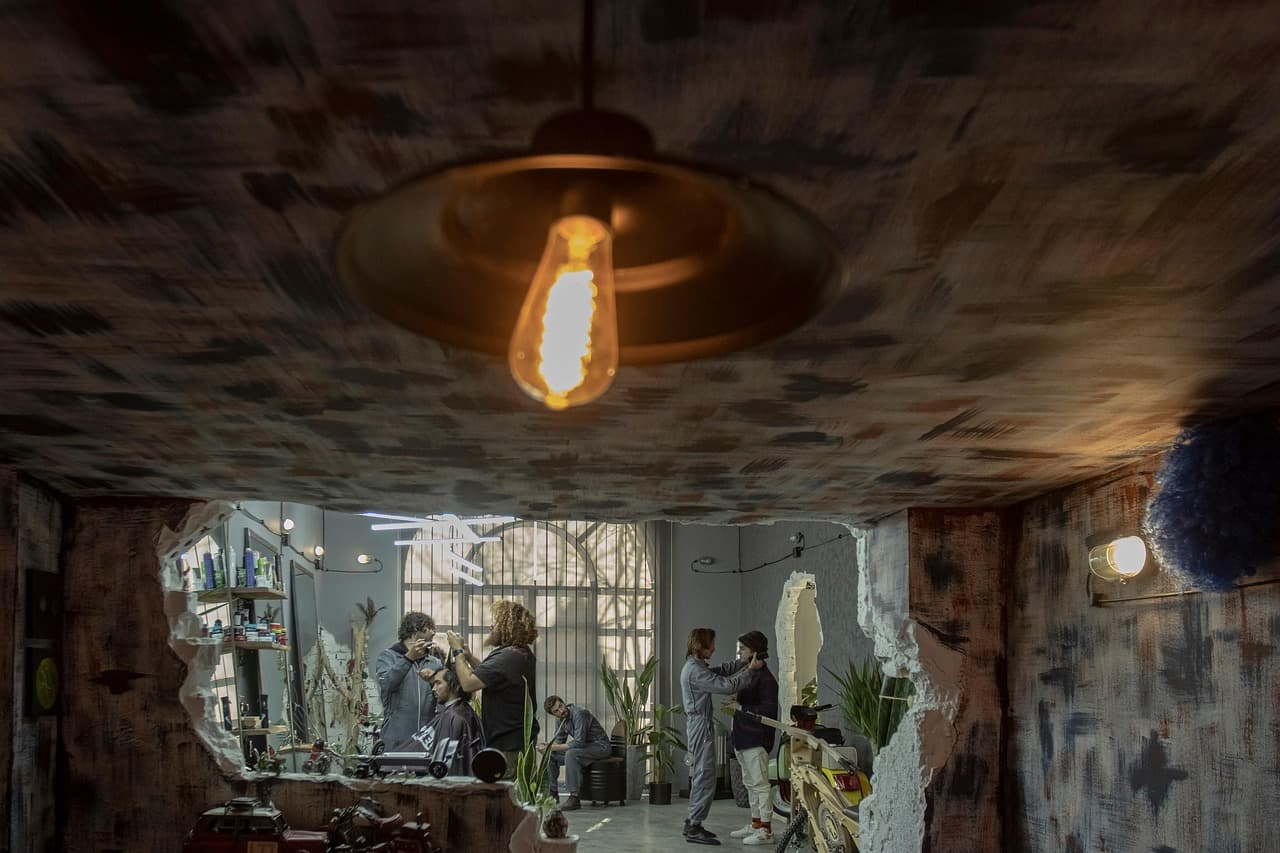 A warm bulb hanging over the chairs of a barber shop